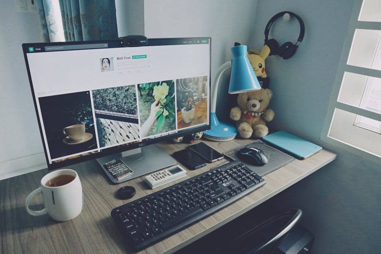 Workspace featuring a computer, keyboard, mouse, and coffee cup on a desk, showcasing an ideal setup for email marketers.