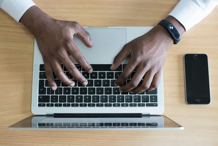 A person's hands typing on a laptop keyboard, focused and engaged in their work.